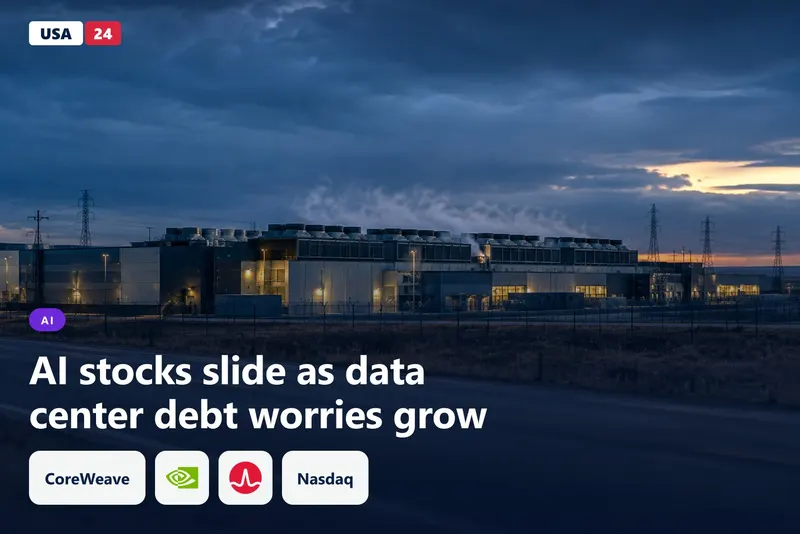 Dusk view of a data center campus with rooftop cooling fans, rising steam and distant power towers under a blue sky.